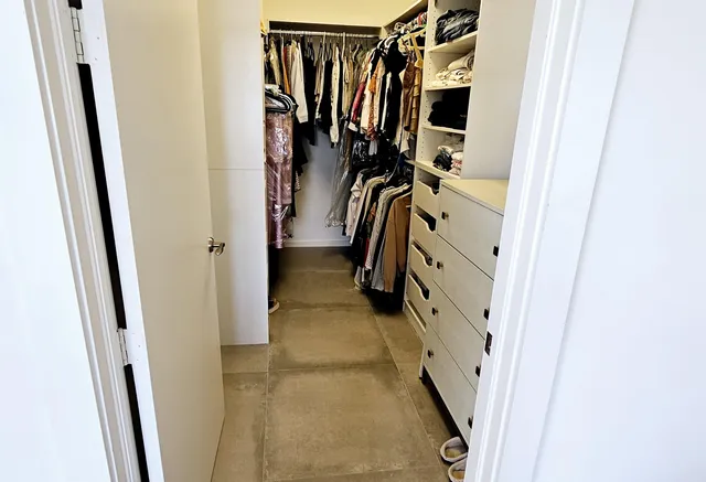 a view of walk in closet with clothes