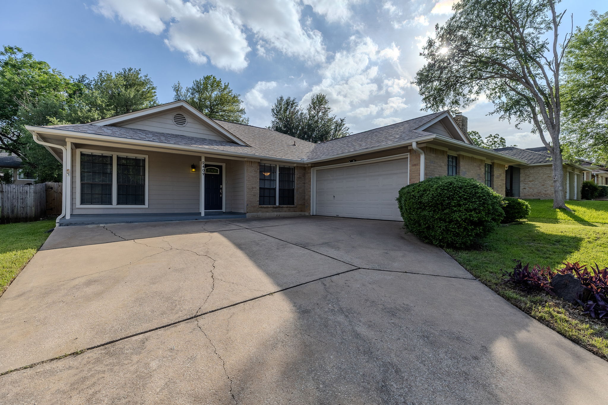 2409 Water Well Lane Austin, TX 78728 - Photo 2 of 22 Ranch-style exterior featuring a combination of brick and siding, a two-car garage, and a concrete driveway