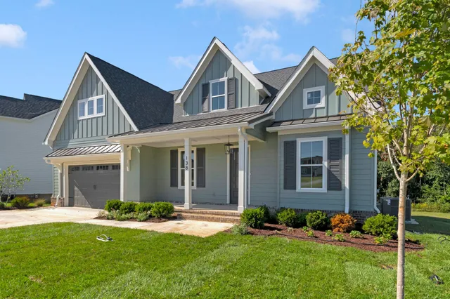 a front view of a house with a yard and trees