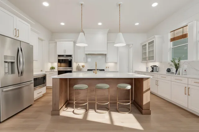 a open kitchen with stainless steel appliances granite countertop a sink a stove and a refrigerator