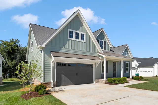 a view of a hallway with wooden floor and a bathroom