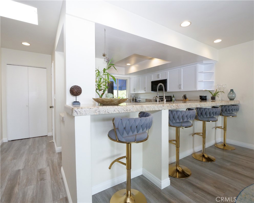 736 Gould Avenue, Unit 26 Hermosa Beach, CA 90254 - Photo 12 of 39 a kitchen with stainless steel appliances granite countertop a stove a refrigerator a oven a sink with island and chairs with wooden floor