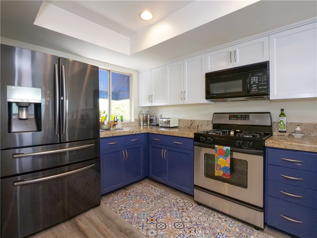 736 Gould Avenue, Unit 26 Hermosa Beach, CA 90254 - Photo 15 of 39 a kitchen with stainless steel appliances granite countertop a stove a refrigerator and a microwave
