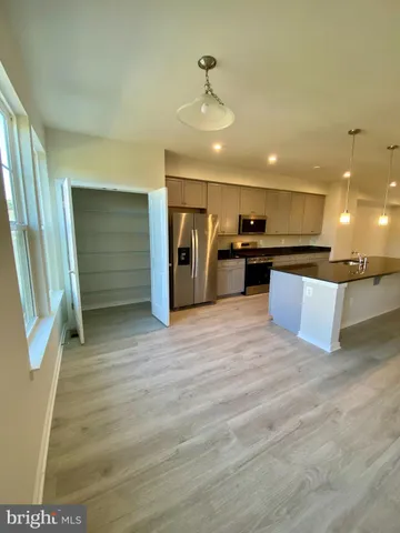 a kitchen with stainless steel appliances granite countertop a sink a stove and a wooden floors