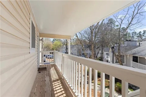 a view of balcony with wooden floor and fence