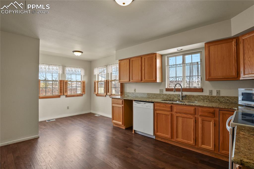 7875 Falcon Meadows Boulevard Peyton, CO 80831 - Photo 15 of 50 a kitchen with granite countertop wooden floors a sink and a window