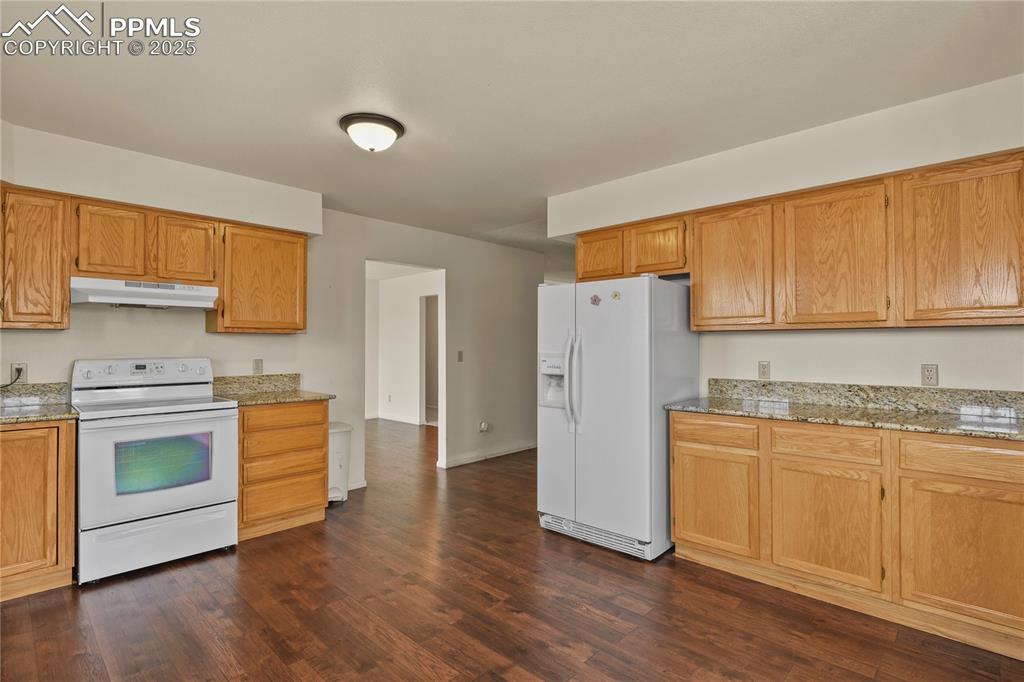 7875 Falcon Meadows Boulevard Peyton, CO 80831 - Photo 17 of 50 a kitchen with a sink a refrigerator a microwave and cabinets