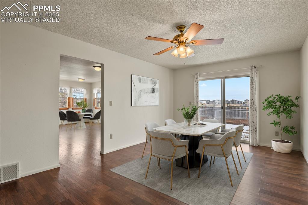 7875 Falcon Meadows Boulevard Peyton, CO 80831 - Photo 19 of 50 a dining room with furniture wooden floor a potted plant and a chandelier
