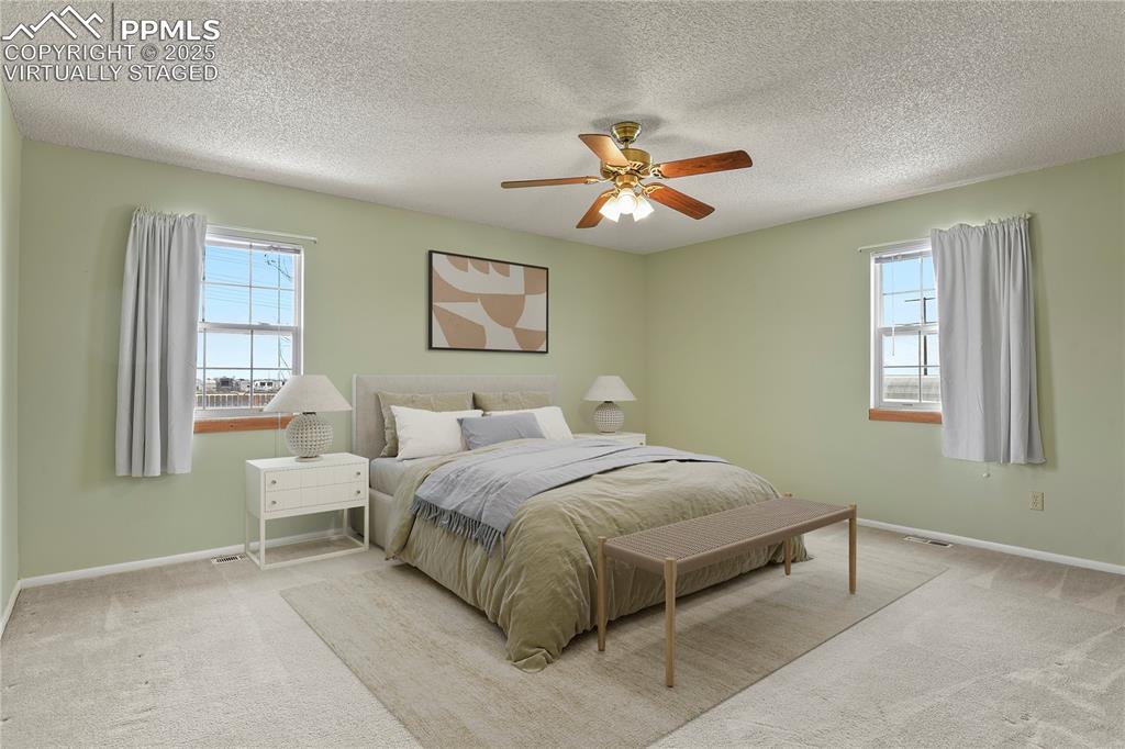7875 Falcon Meadows Boulevard Peyton, CO 80831 - Photo 22 of 50 a bedroom with a bed and a chandelier