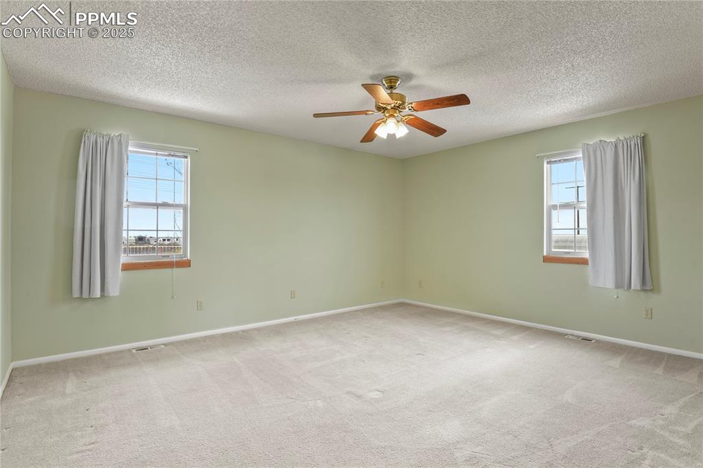 7875 Falcon Meadows Boulevard Peyton, CO 80831 - Photo 23 of 50 an empty room with windows and fan