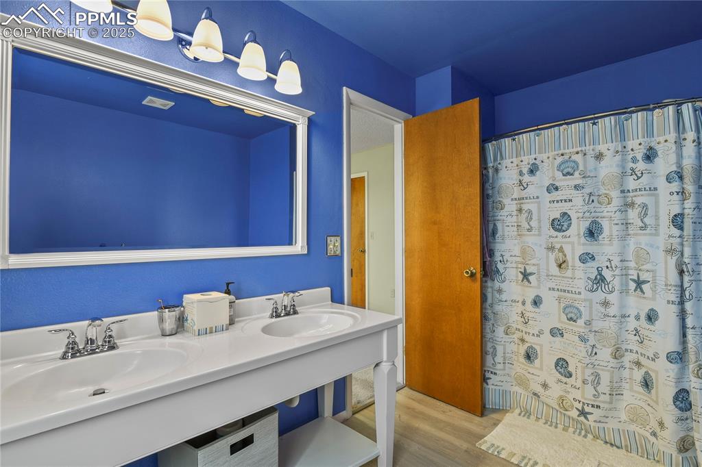 7875 Falcon Meadows Boulevard Peyton, CO 80831 - Photo 27 of 50 a bathroom with a sink a mirror and a shower