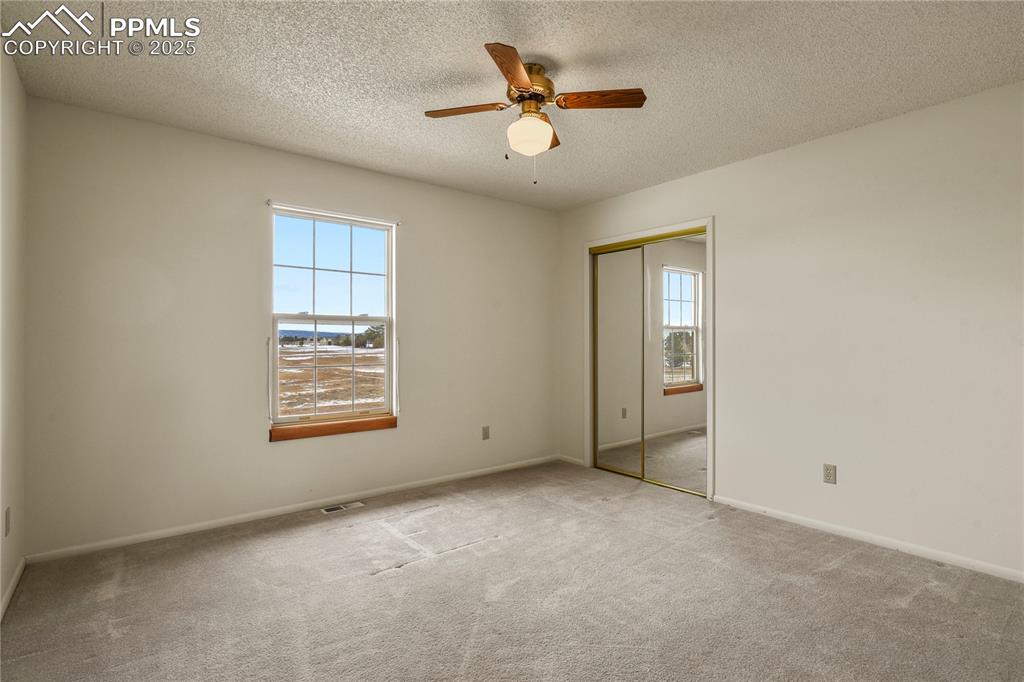 7875 Falcon Meadows Boulevard Peyton, CO 80831 - Photo 29 of 50 an empty room with windows and fan