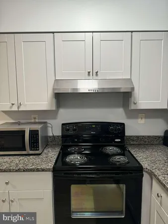a stove top oven sitting inside of a kitchen