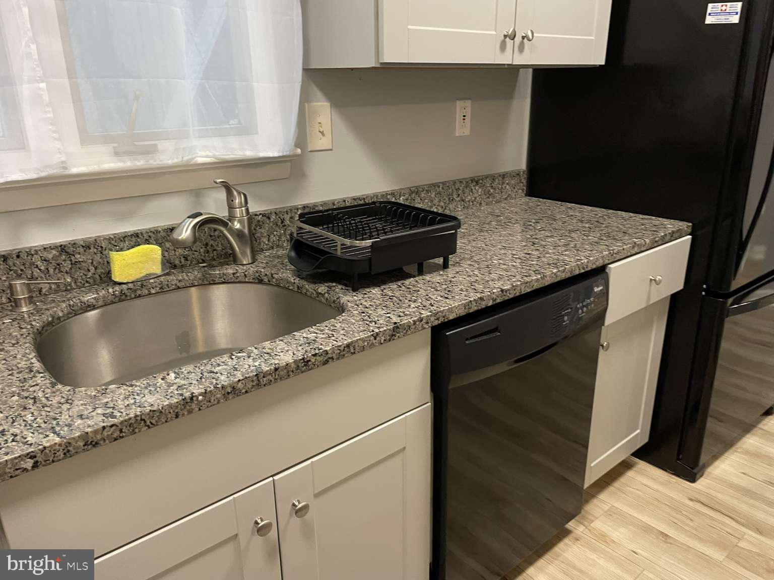 39633 Round Robin Way, Unit 2602 Bethany Beach, DE 19930 - Photo 10 of 43 a kitchen with granite countertop a sink dishwasher and cabinets with wooden floor