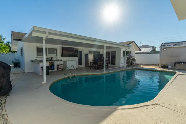 a front view of a house with a yard and potted plants