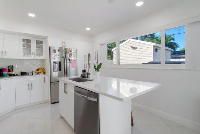 a kitchen with stainless steel appliances granite countertop a refrigerator and a stove top oven