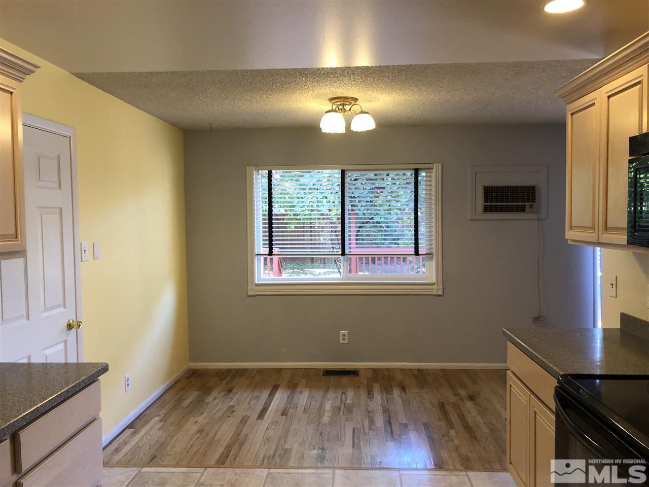 695 Ibis Lane Reno, NV 89503 - Photo 4 of 14 a view of an empty room with window and wooden floor