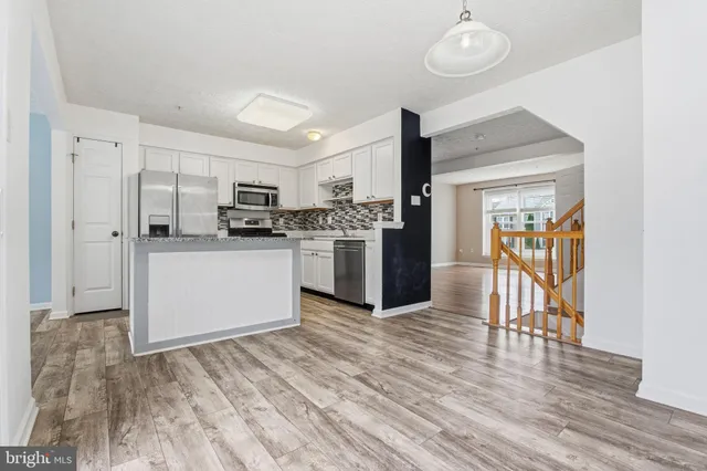 a kitchen with stainless steel appliances granite countertop a refrigerator and a stove top oven