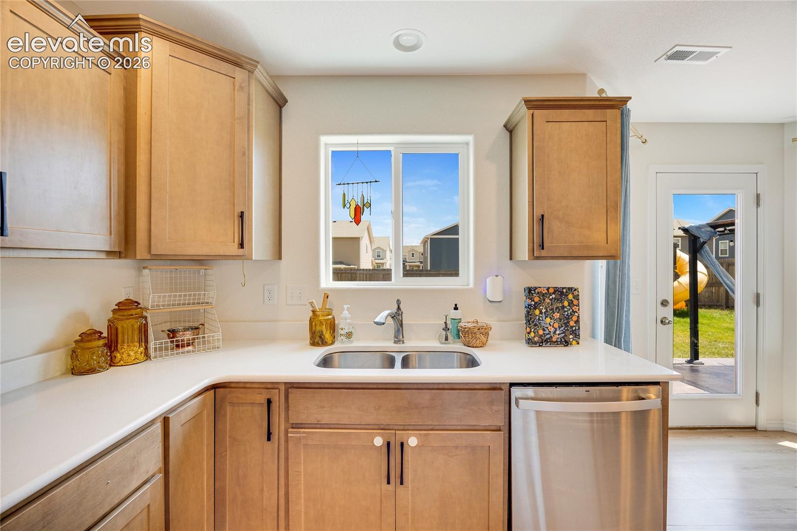 10993 Avena Road Peyton, CO 80831 - Photo 16 of 42 Kitchen featuring light wood cabinetry, a double basin stainless steel sink, a stainless steel dishwasher, a white countertop, and recessed lighting