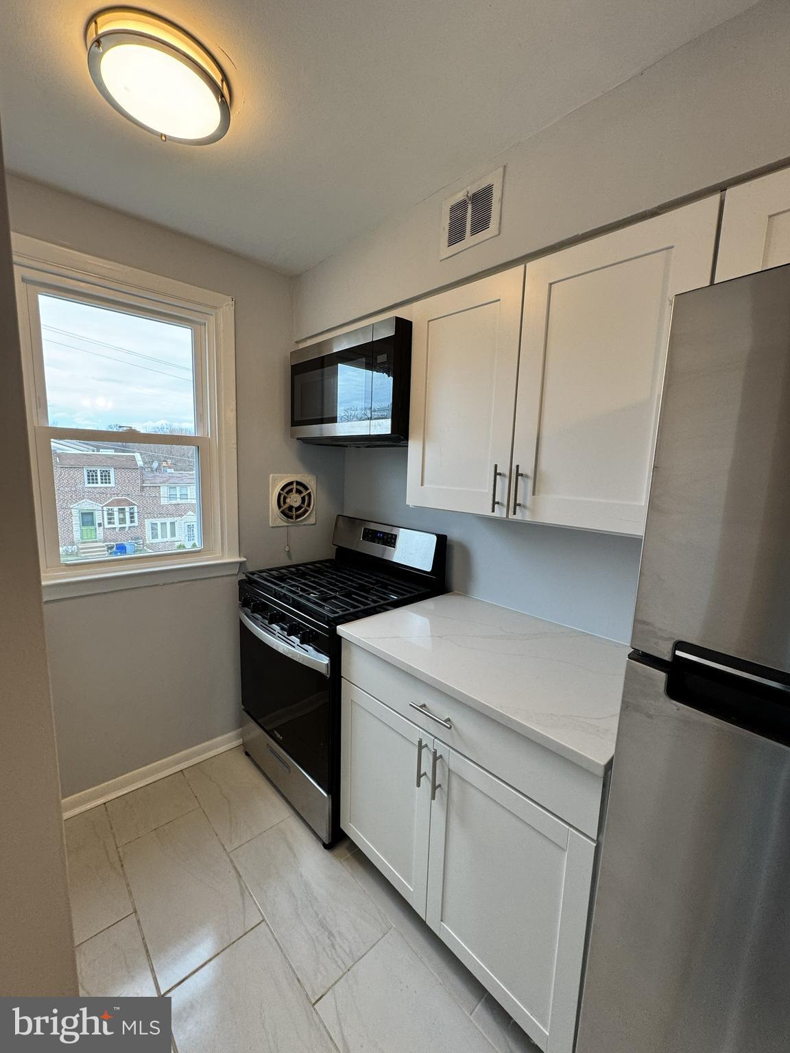 5099 Palmers Mill Road, Unit 2 Clifton Heights, PA 19018 - Photo 7 of 11 a kitchen with stainless steel appliances granite countertop a stove a sink and a refrigerator