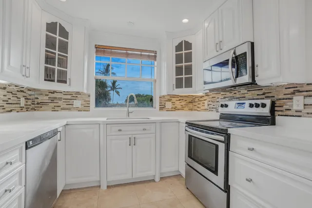 a kitchen with white cabinets stainless steel appliances and sink