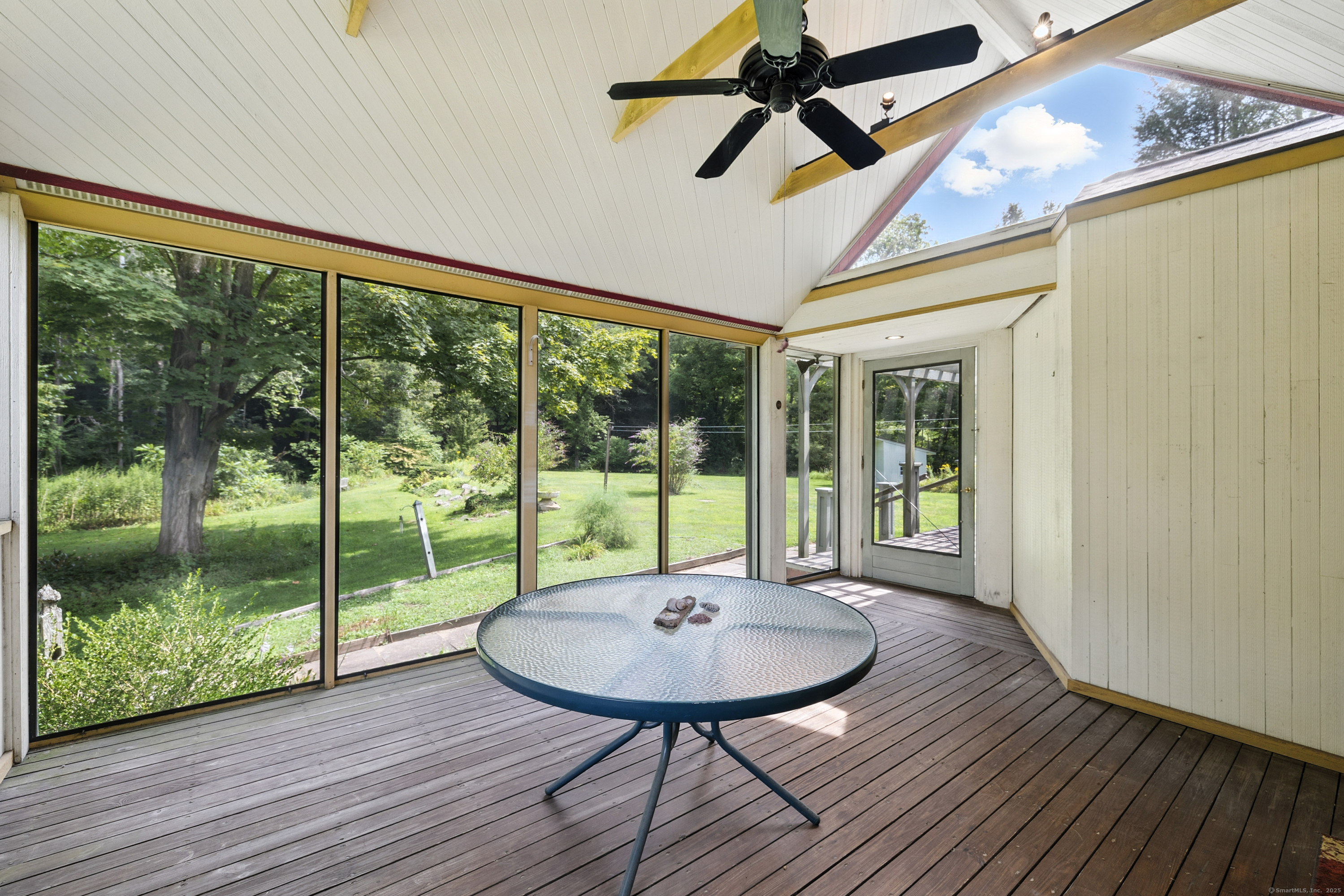 326 Litchfield Road New Milford, CT 06776 - Photo 9 of 40 a view of a patio with a table chairs and wooden floor
