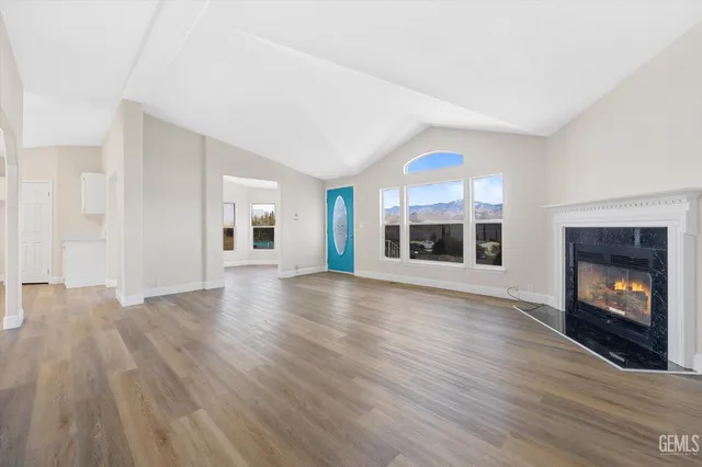 a view of a livingroom with wooden floor and a fireplace