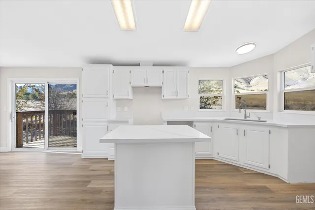 a kitchen with granite countertop a sink window and cabinets