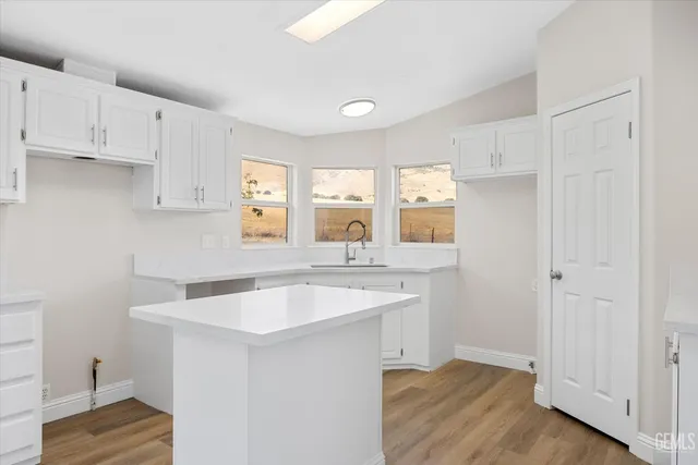 a white kitchen with sink and window