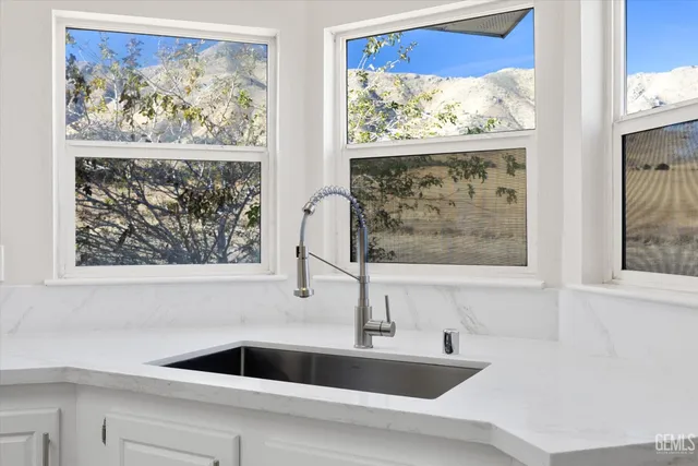 a bathroom with a sink mirror and a window