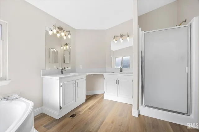 a bathroom with a double vanity sink mirror and shower