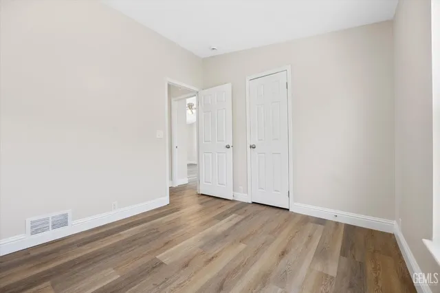 a view of an empty room with wooden floor
