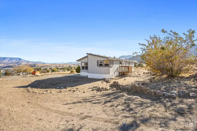 a view of a dry yard with wooden fence