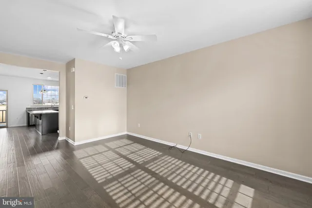 a view of a livingroom with wooden floor and a ceiling fan