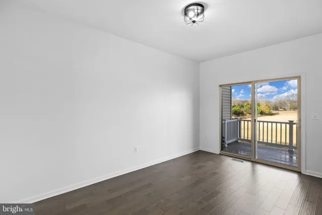 a view of a room with wooden floor and a window