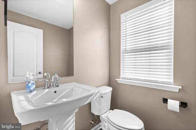 a bathroom with a sink a toilet and a window