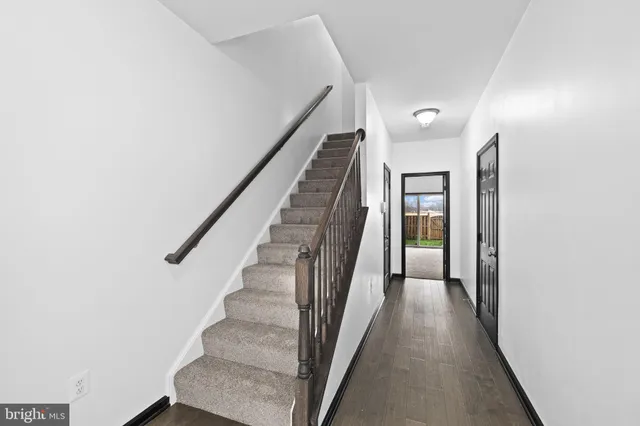 a view of a hallway with wooden floor and entryway