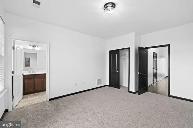 a view of an empty room with closet and bathroom