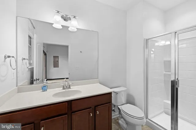 a bathroom with a sink a toilet a mirror and shower