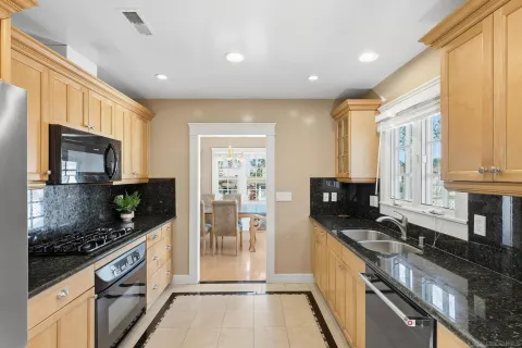 a large kitchen with stainless steel appliances granite countertop a stove a sink and a microwave