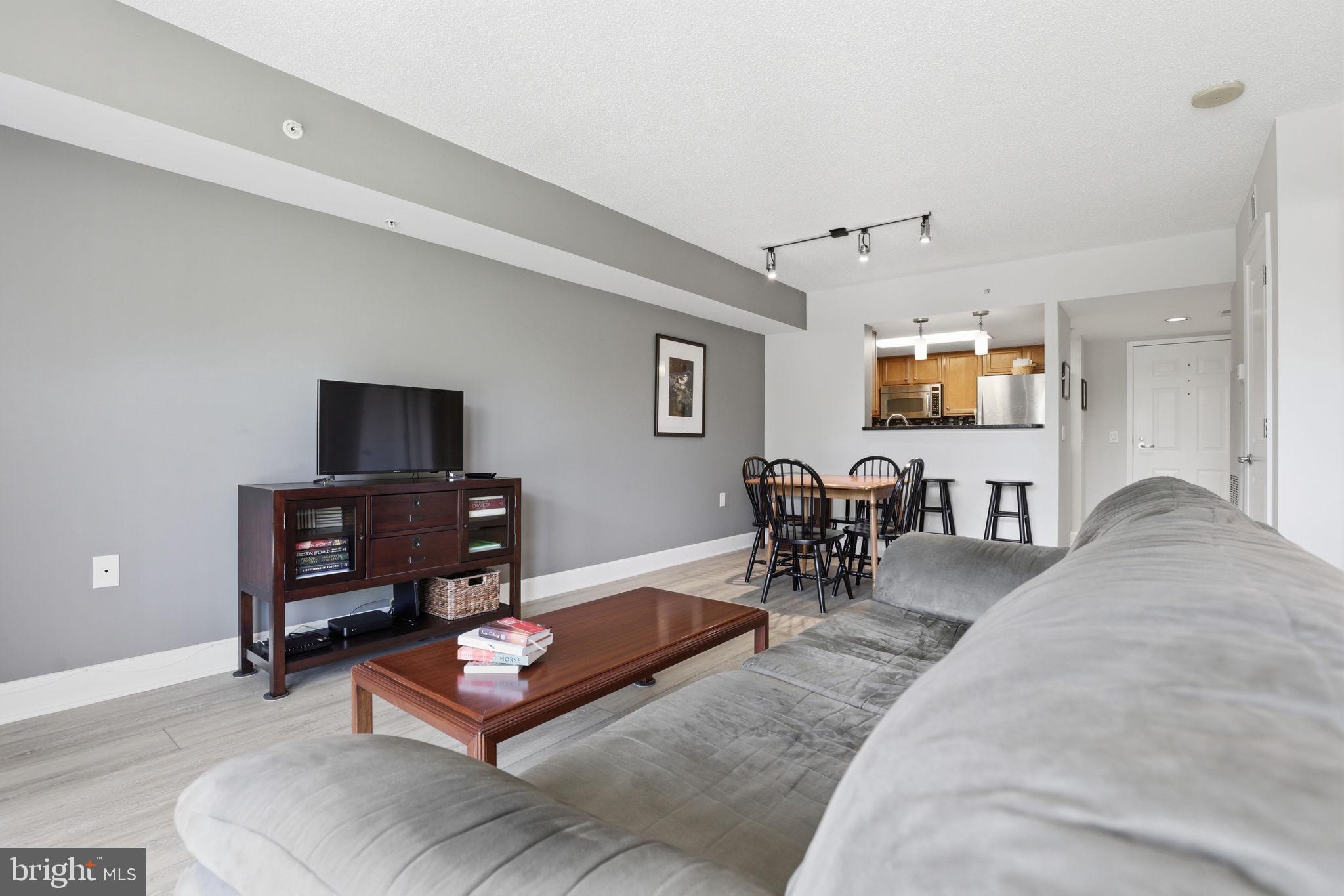 11800 Sunset Hills Road, Unit 218 Reston, VA 20190 - Photo 4 of 38 a living room with furniture a dining table and chairs