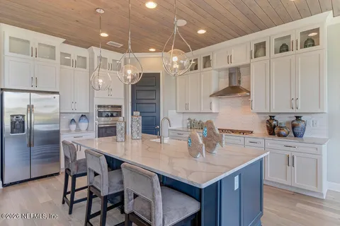 a kitchen with granite countertop a table chairs stainless steel appliances and cabinets
