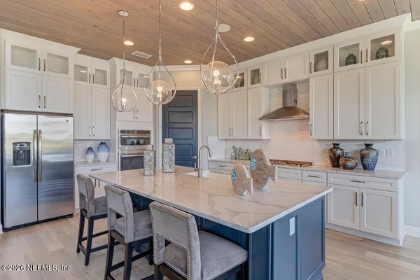 a kitchen with granite countertop a table chairs stainless steel appliances and cabinets