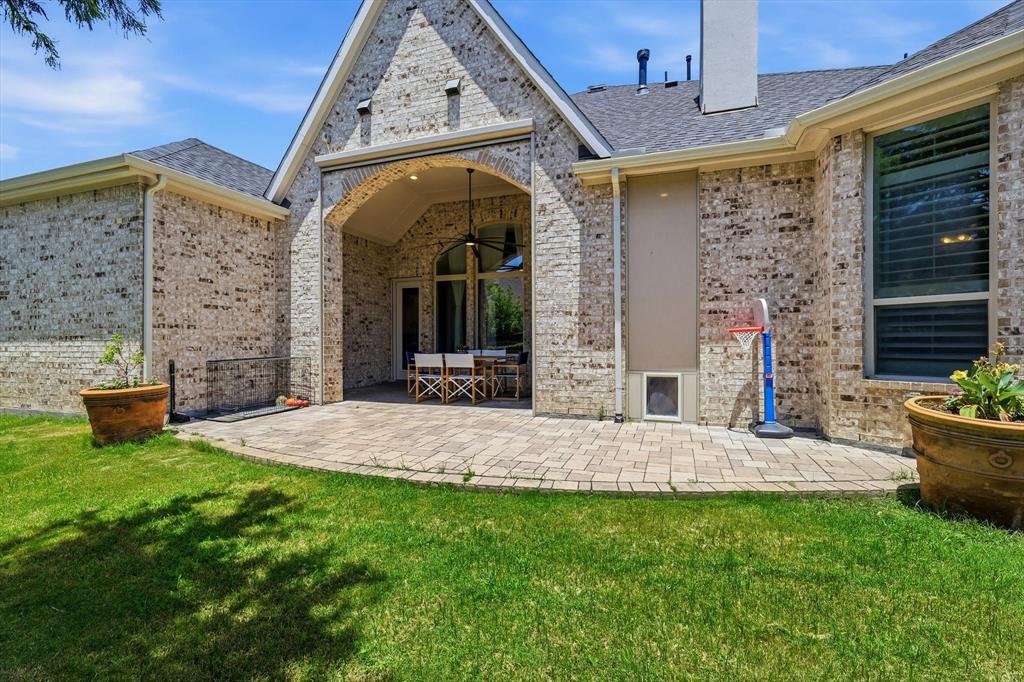 1933 Snapdragon Road Frisco, TX 75033 - Photo 37 of 40 Expansive paver patio featuring an arched covered outdoor living area with a ceiling fan