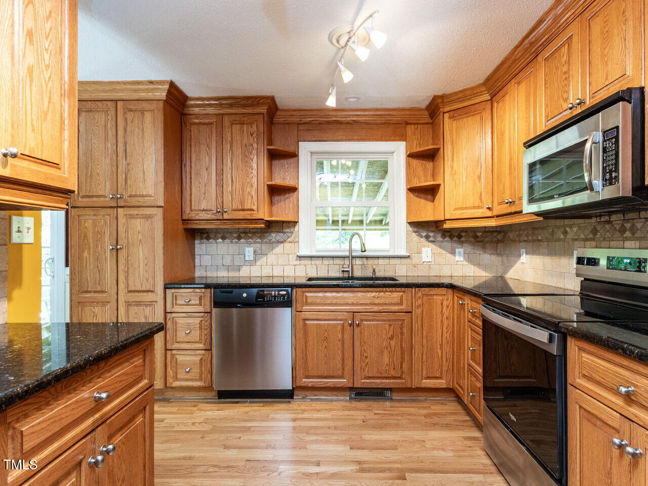 525 Turtle Creek Farm Road Apex, NC 27523 - Photo 5 of 36 a kitchen with stainless steel appliances granite countertop wooden cabinets a stove a sink and a window
