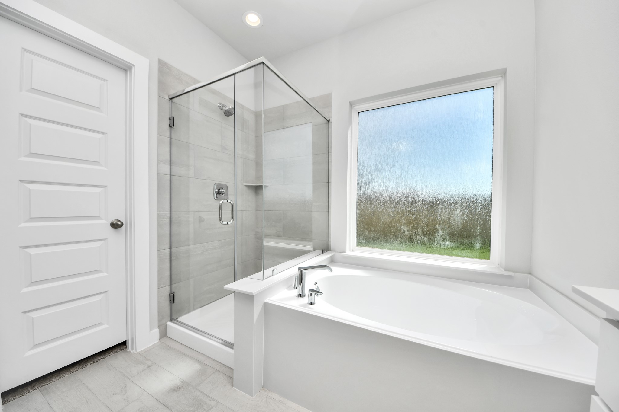 2910 Burris Park Drive Spring, TX 77373 - Photo 22 of 34 Indulge in a spa-like retreat within the confines of this primary bathroom. Delight in a spacious walk-in shower enveloped in stylish tile surround, unwind in a separate garden tub adorned with custom detailing. Sample photo of completed home with similar floor plan. Actual colors and selections may vary.