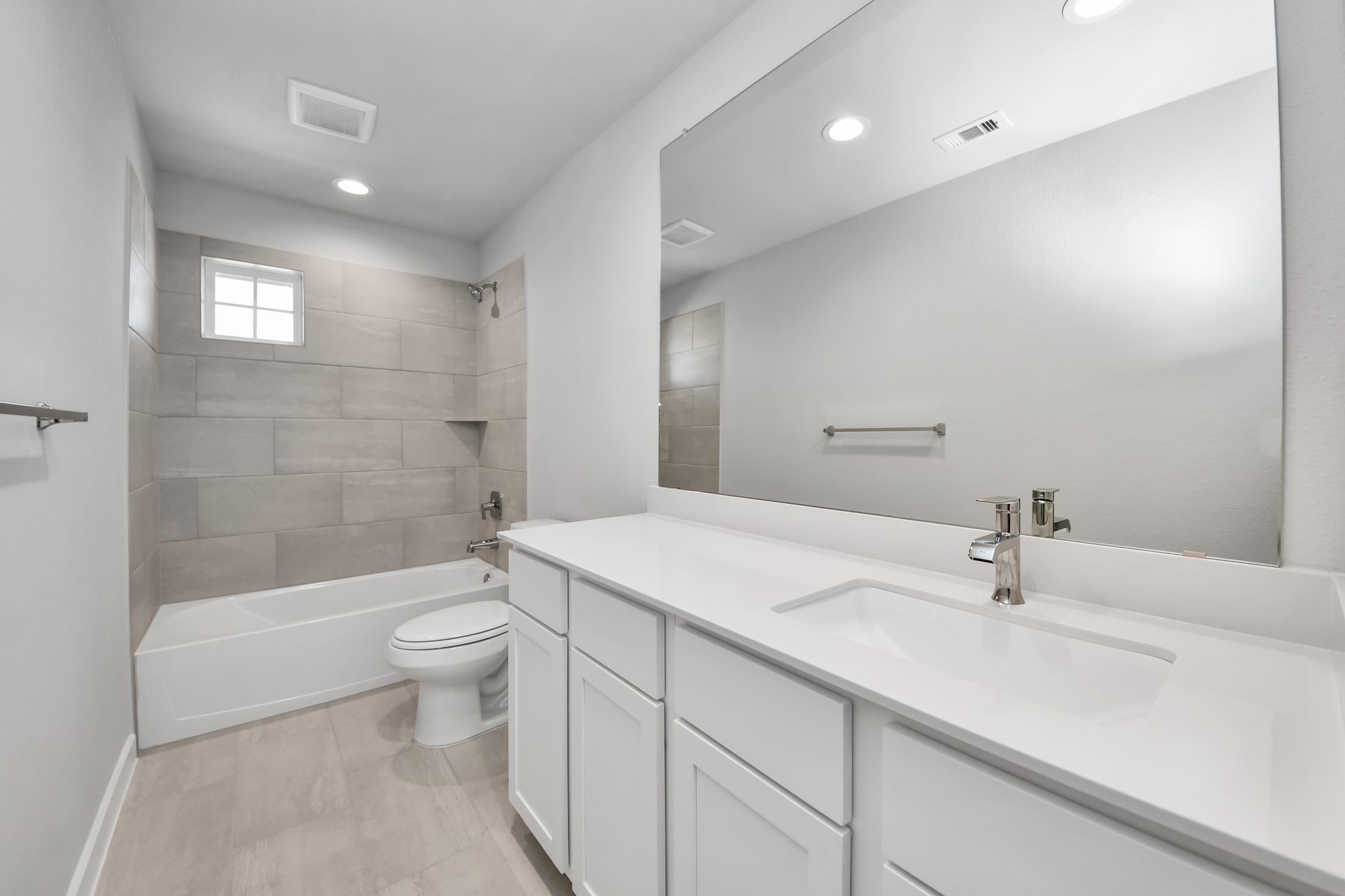 2910 Burris Park Drive Spring, TX 77373 - Photo 29 of 34 Secondary bath features tile flooring, bath/shower combo with tile surround, light stained wood cabinets, beautiful light countertop. Sample photo of completed home with similar floor plan. Actual colors and selections may vary.