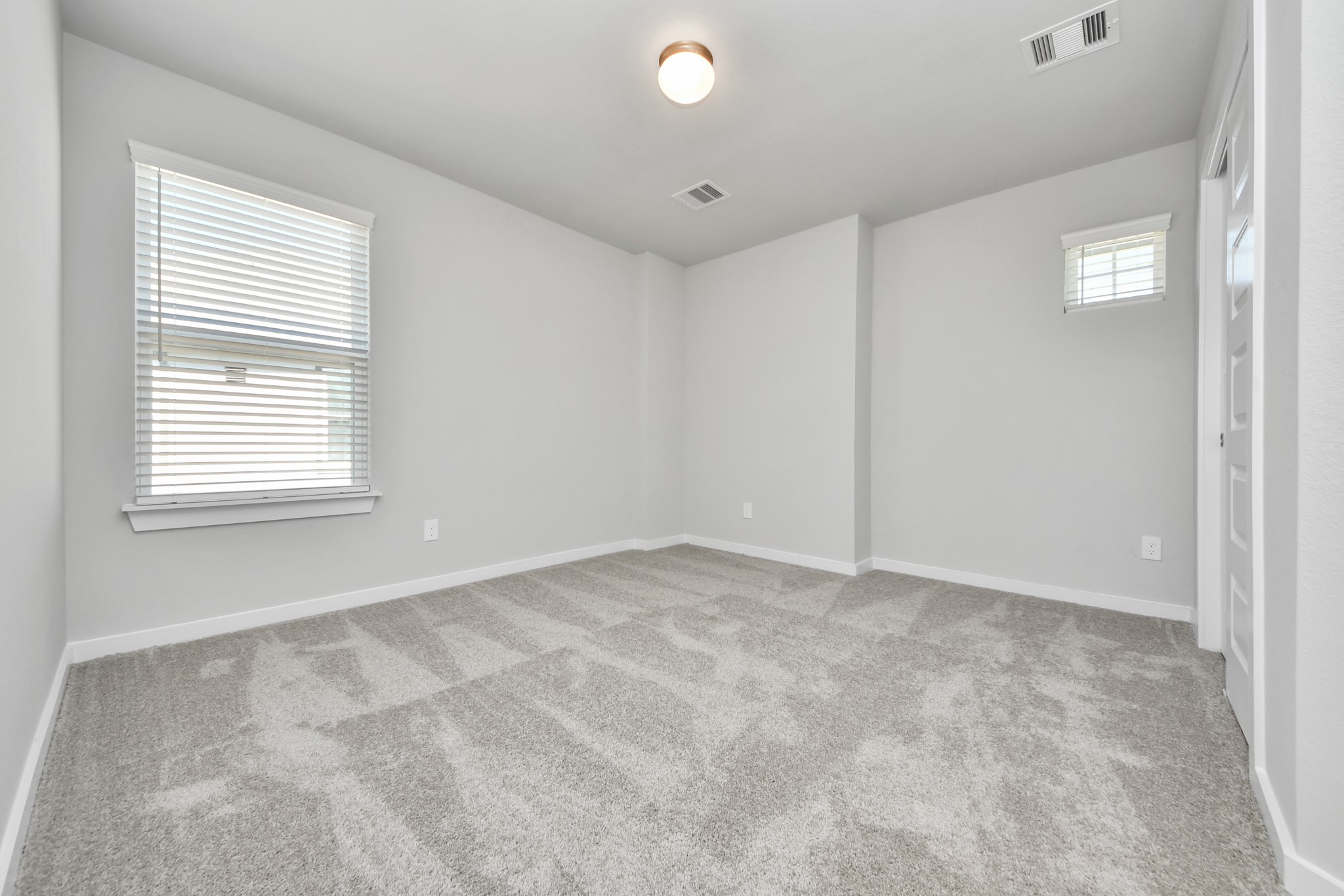 2910 Burris Park Drive Spring, TX 77373 - Photo 31 of 34 Secondary bedroom features plush carpeting, large windows that let in plenty of natural light, bright paint, and spacious closets. Sample photo of completed home with similar floor plan. Actual colors and selections may vary.
