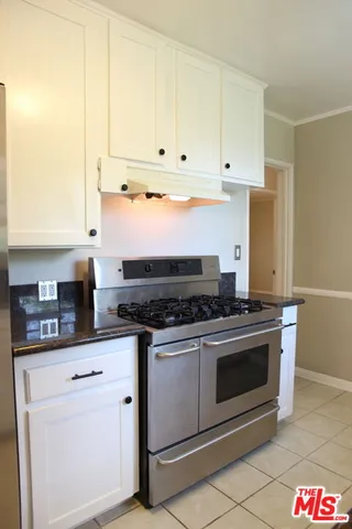 a kitchen with white cabinets and appliances