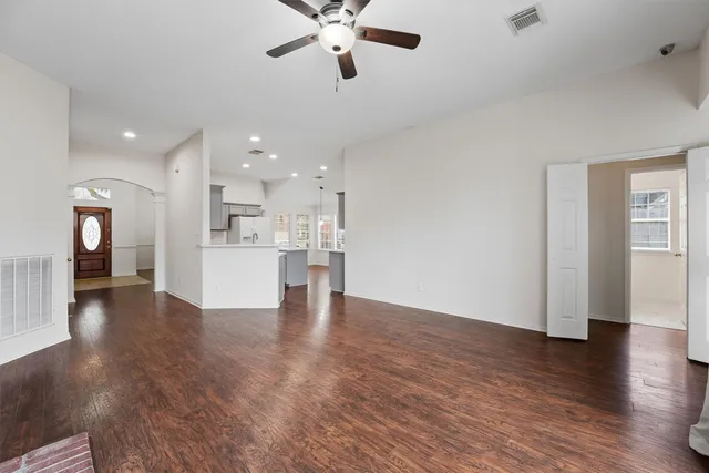 a view of a kitchen with a fridge wooden floor and a window